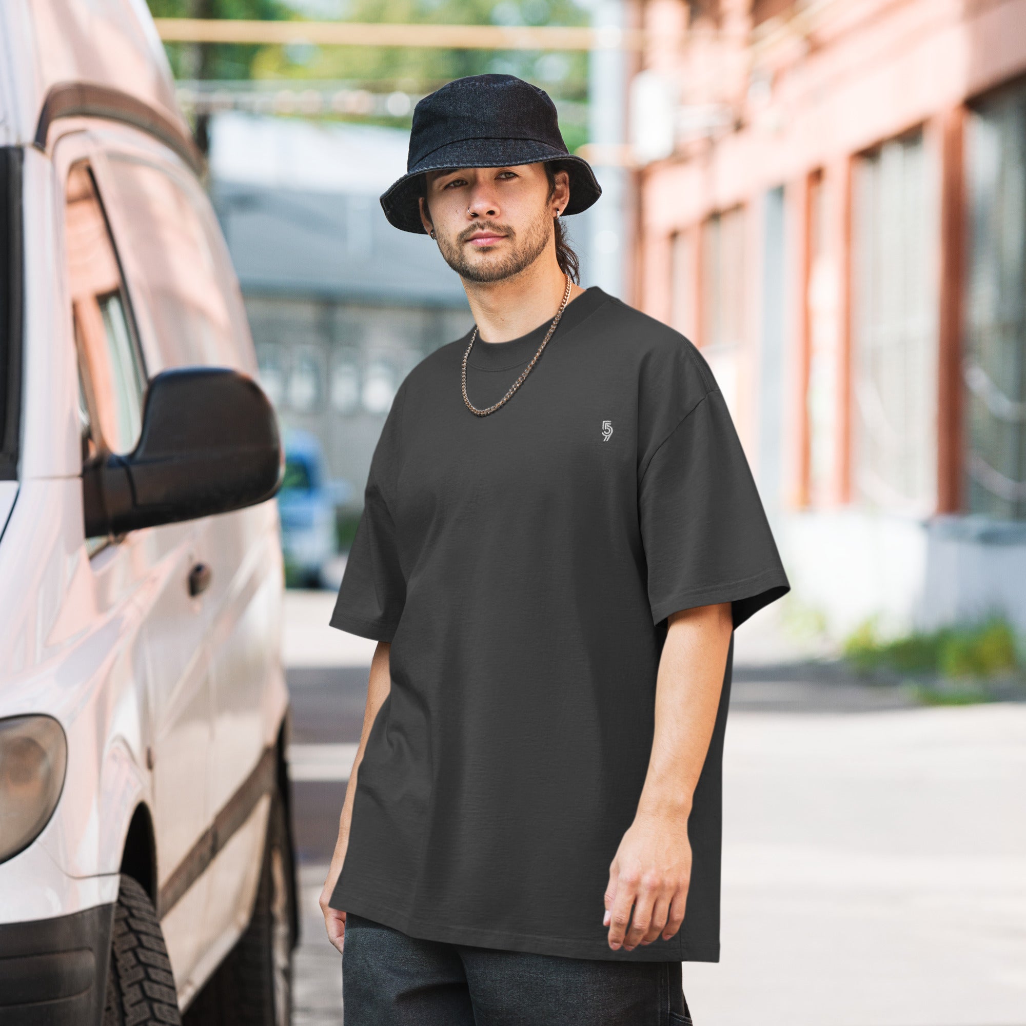 A man standing outside wearing 905 streetwear clothing.