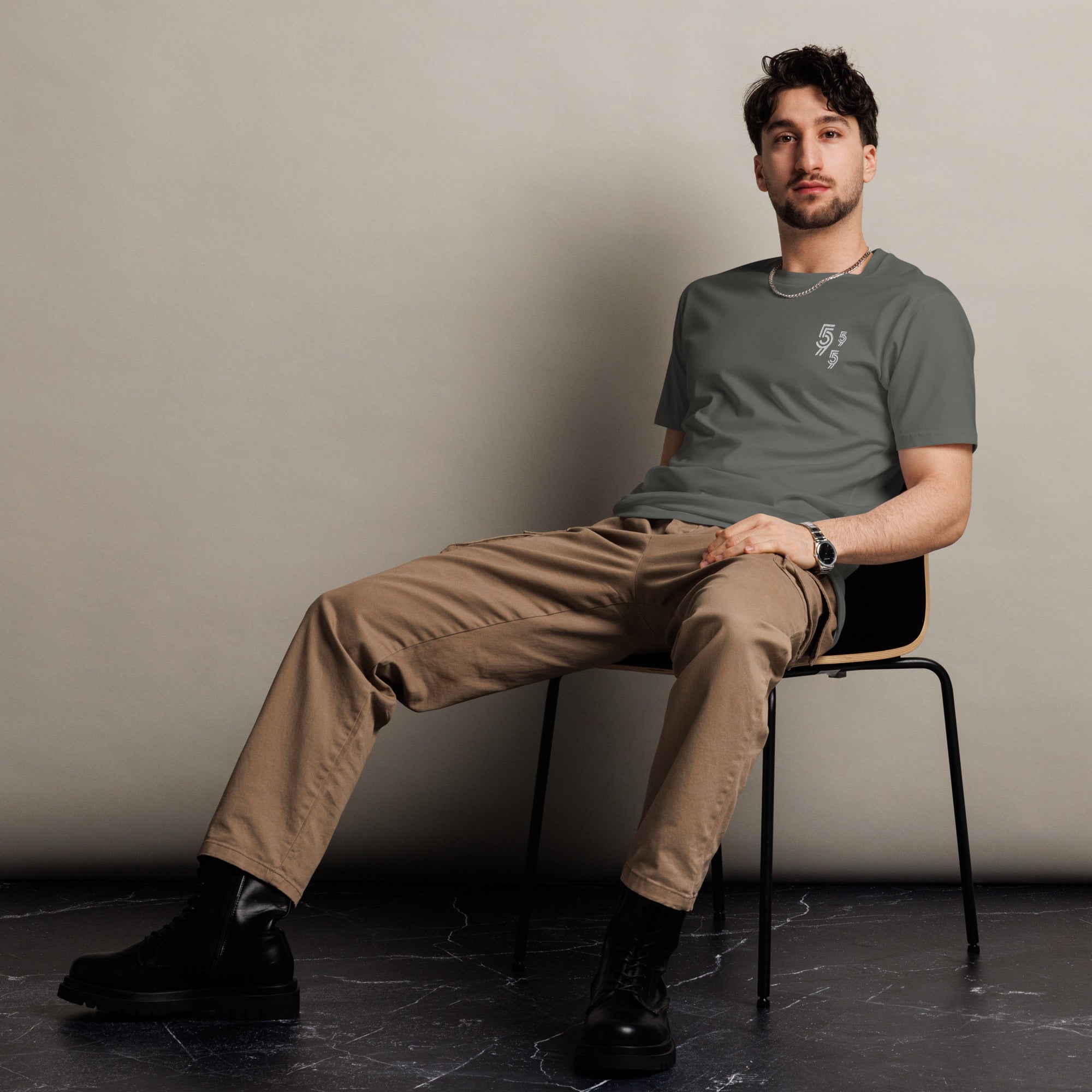 A man sitting in a chair wearing a 905 streetwear brands t-shirt